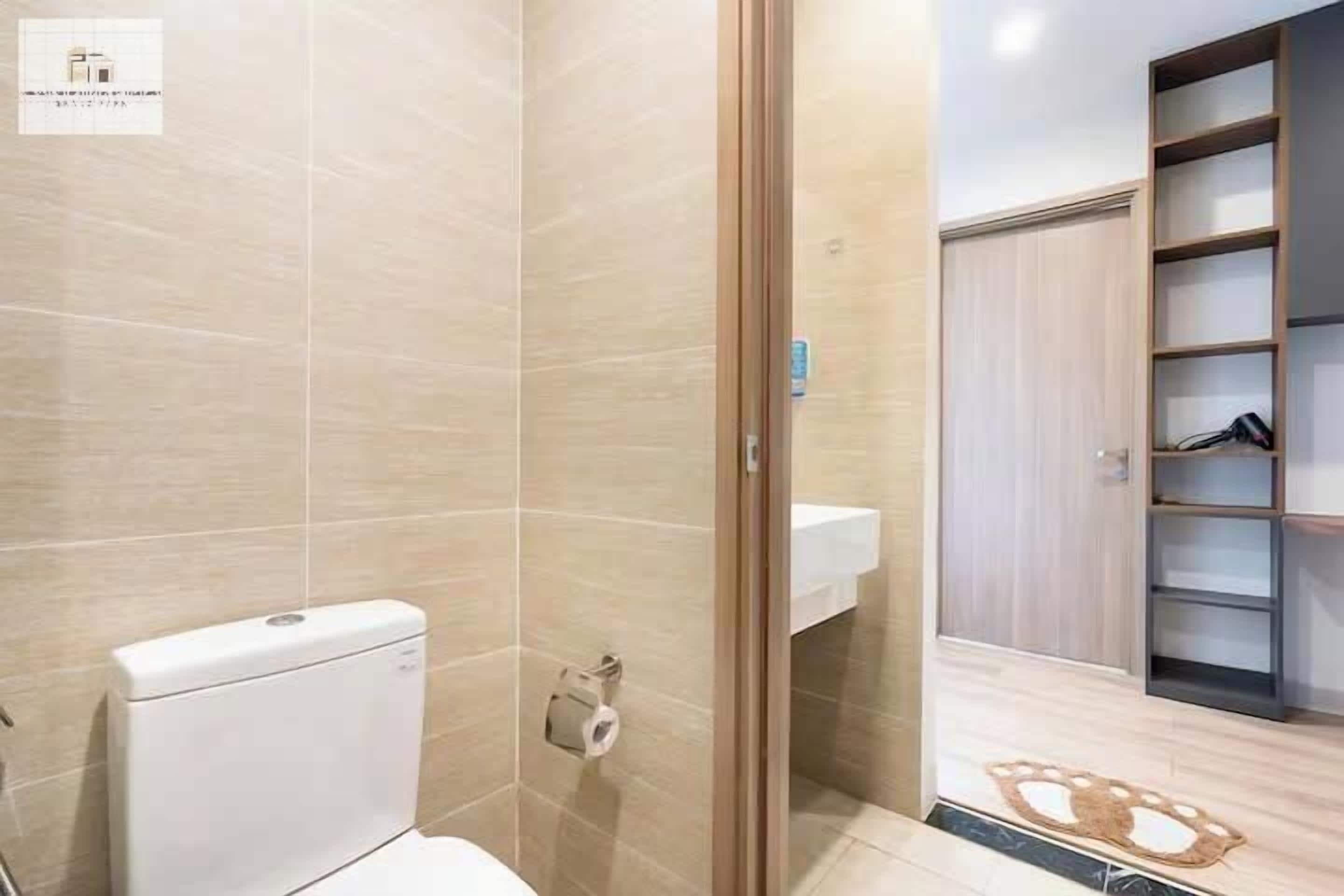 A modern bathroom with a toilet, a towel rack, and a shower area.