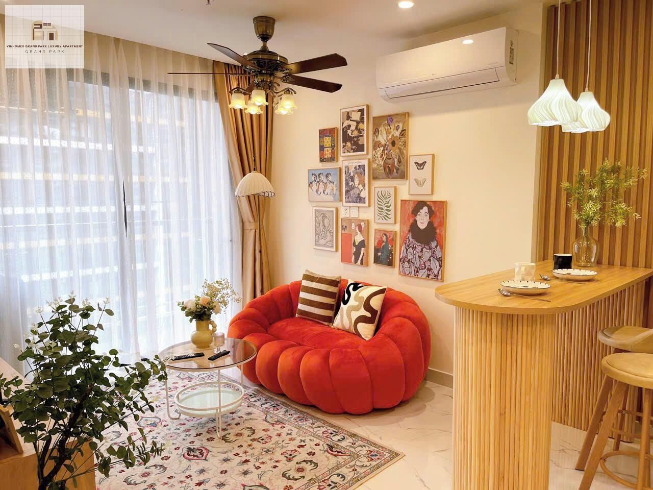 Una sala de estar moderna con un sillón informal rojo, una mesita de centro redonda y una pequeña zona de bar.