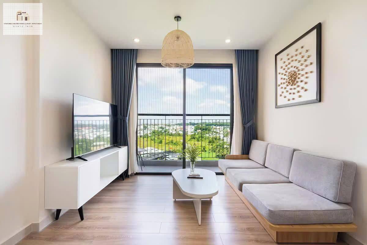 En moderne stue med tv, sofa og en balkon med udsigt.