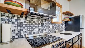 Una cocina con salpicadero de diseño, estufa, fregadero y refrigerador.
