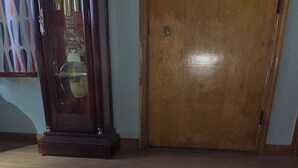 Una habitación con puerta de madera, un tapete estampado y una cama con un colchón rosa.