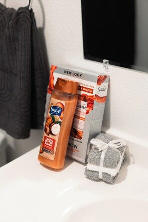 Secadora de cabello, toallas, jabón, papel de baño