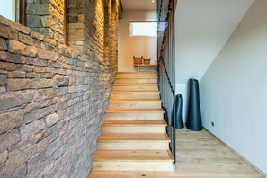 Stairs lead to an upper level with a window and a shelf with two baskets.