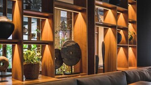 A modern interior with wooden shelving, a seating area, and potted plants. - iSuite by Ekosistem (Keroboken Kelod)