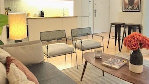 A modern living room with a sofa, a coffee table, and a dining area with chairs. - Alfama S Loft (Lisboa)