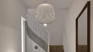 A staircase with a checkered floor, a white wall, and a hanging light fixture. - Alfama S Loft (Lisboa)