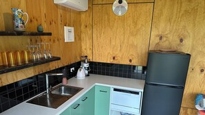 Eine Küche mit Spüle, Kaffeemaschine, Kühlschrank und Mikrowelle.