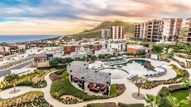 Ein Resort mit einem zentralen Pool, angelegten Gärten und mehreren Gebäuden mit Balkonen.