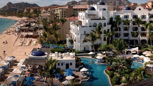 Ein Resort mit Pool, Strand und Palmen.