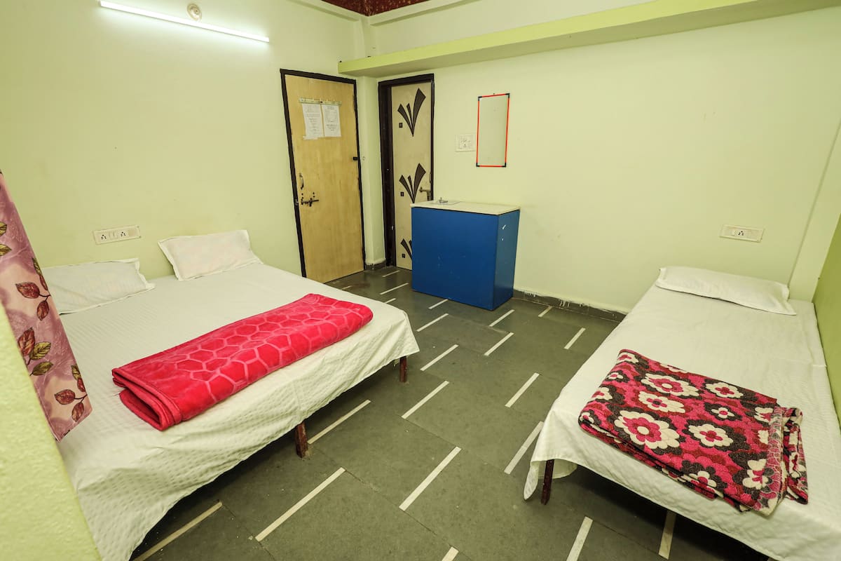 A room with two beds, a desk, and a door.