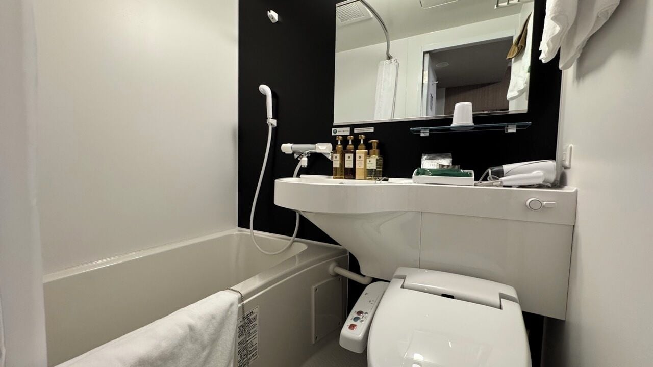 A modern bathroom with a bathtub, toilet, and sink.