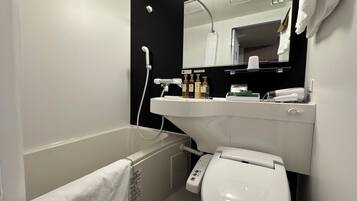 A modern bathroom with a bathtub, toilet, and sink.