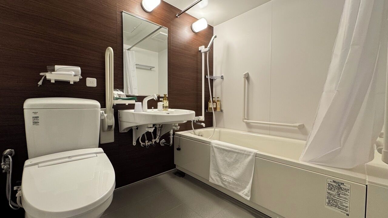 A modern bathroom with a toilet, sink, and bathtub.