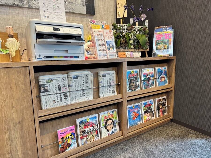 A reception desk with a printer, magazines, and a bulletin board.