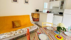 A living room with a sofa, a dining table with chairs, and a kitchen area with cabinets and appliances. - 🌼 Villa aux Capellans with terrace and pool 🌼 (Saint-Cyprien)