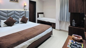 A modern hotel room with a large bed, a smaller bed, a desk with a computer, and a TV. - Hotel Care Residency (Indore)