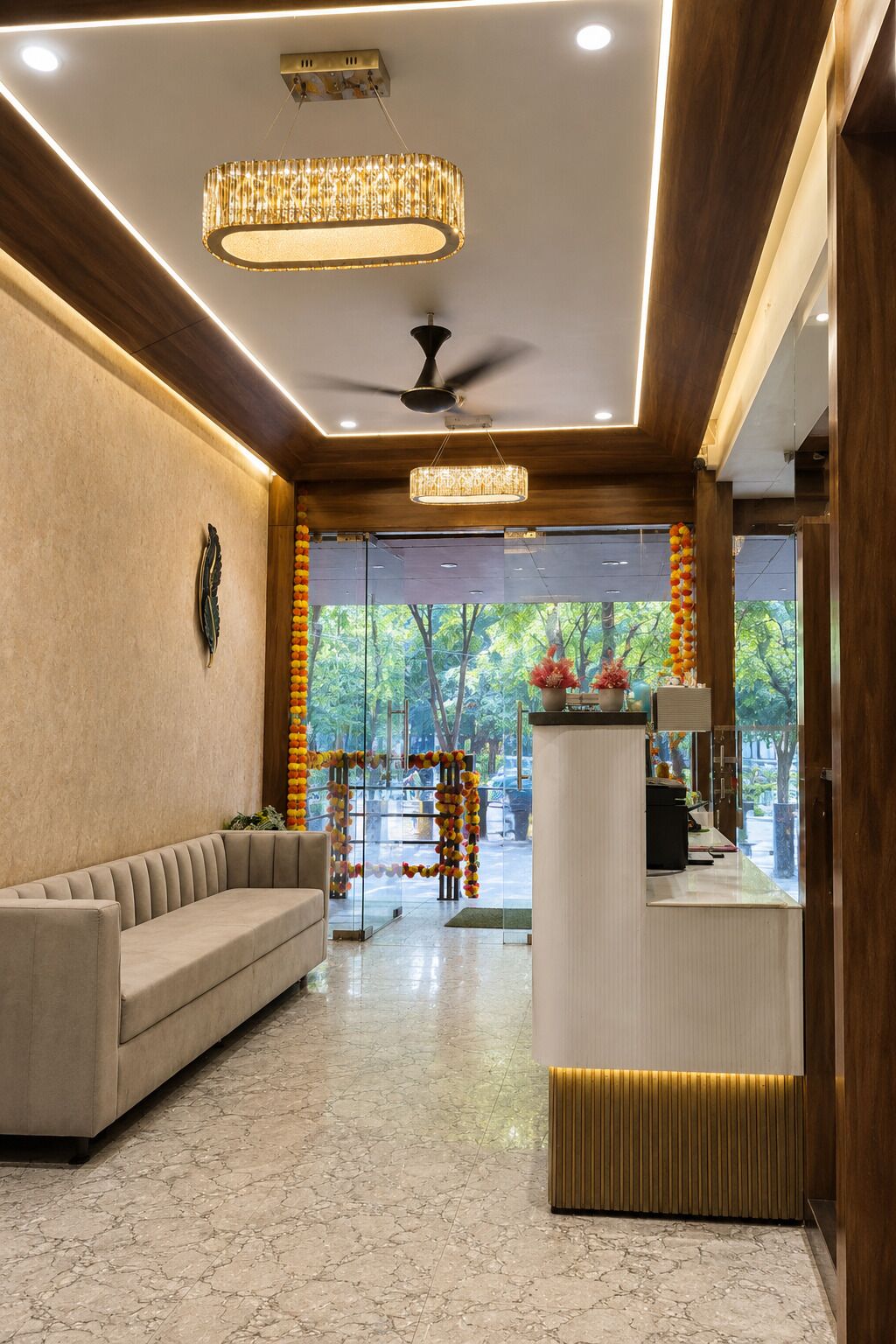 A hotel lobby with a sofa, reception desk, and a ceiling fan.