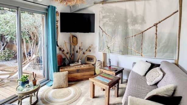 Una sala de estar acogedora con un ventanal grande, un televisor y una mesa de centro de madera rústica.