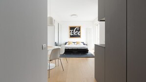 Et moderne hotelværelse med seng, skrivebord og stol.