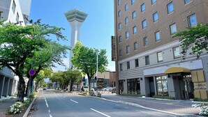 A hotel with a modern design, featuring a prominent tower structure in the background. - Hotel BRS Hakodate Goryokaku Tower (Hakodate)