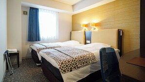 A hotel room with two beds, a desk, a chair, a window with curtains, and a wall-mounted lamp. - Hotel BRS Hakodate Goryokaku Tower (Hakodate)