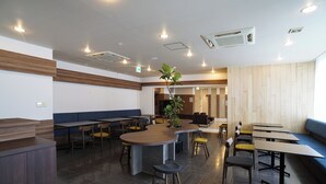A modern restaurant with a central bar area, multiple seating options including booths and tables, and a herringbone-patterned floor. - Hotel BRS Hakodate Goryokaku Tower (Hakodate)