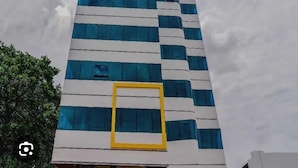 A tall building with a modern design, featuring horizontal lines and rectangular windows. - Hotel RAAJASGRAND (Tirupati)