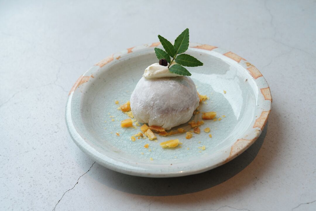 A dessert on a plate with a decorative leaf garnish.