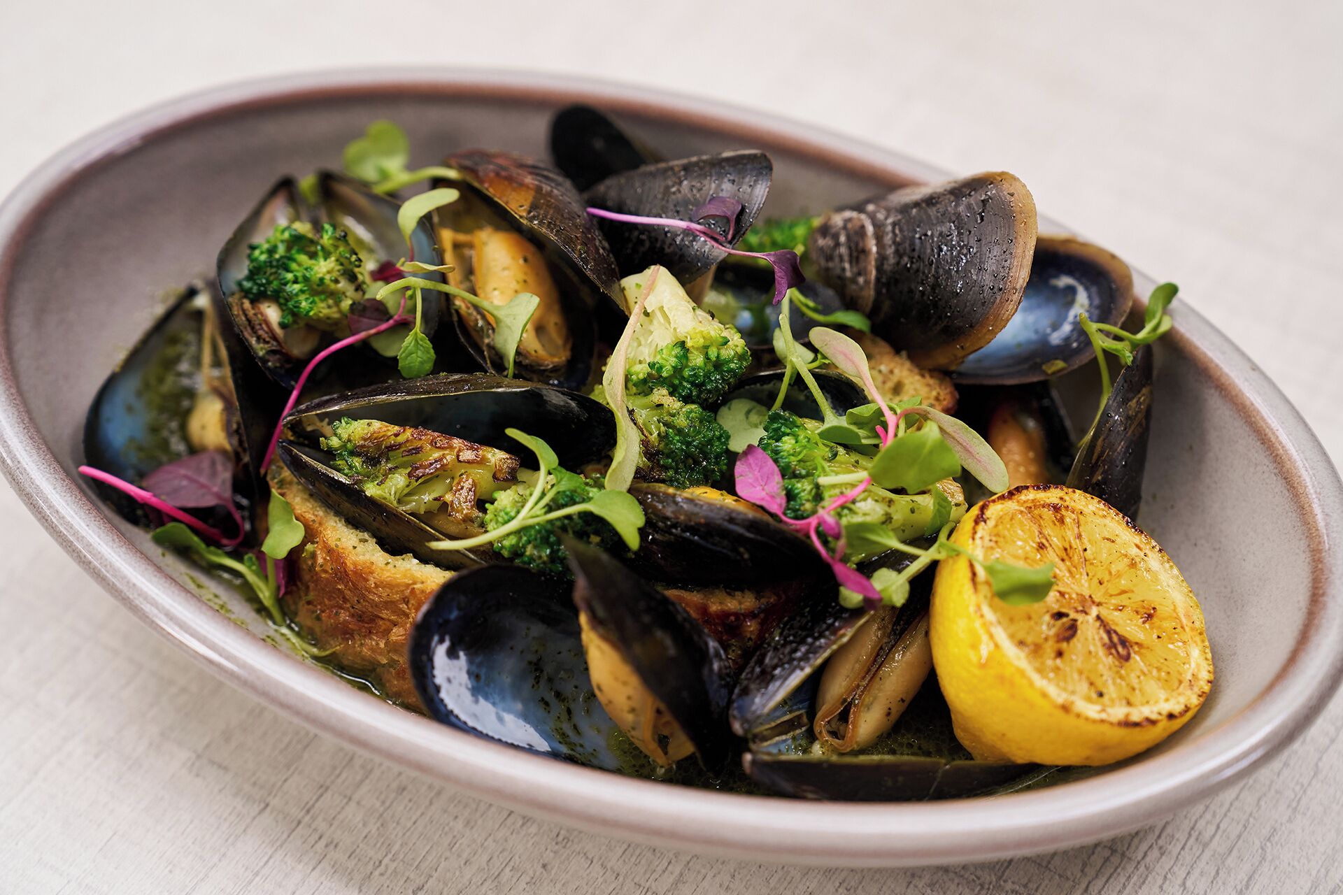 A dish of mussels with vegetables and herbs.