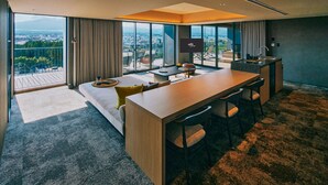 Une chambre d’hôtel moderne dotée d’un grand balcon, d’un coin repas et d’une télévision.
