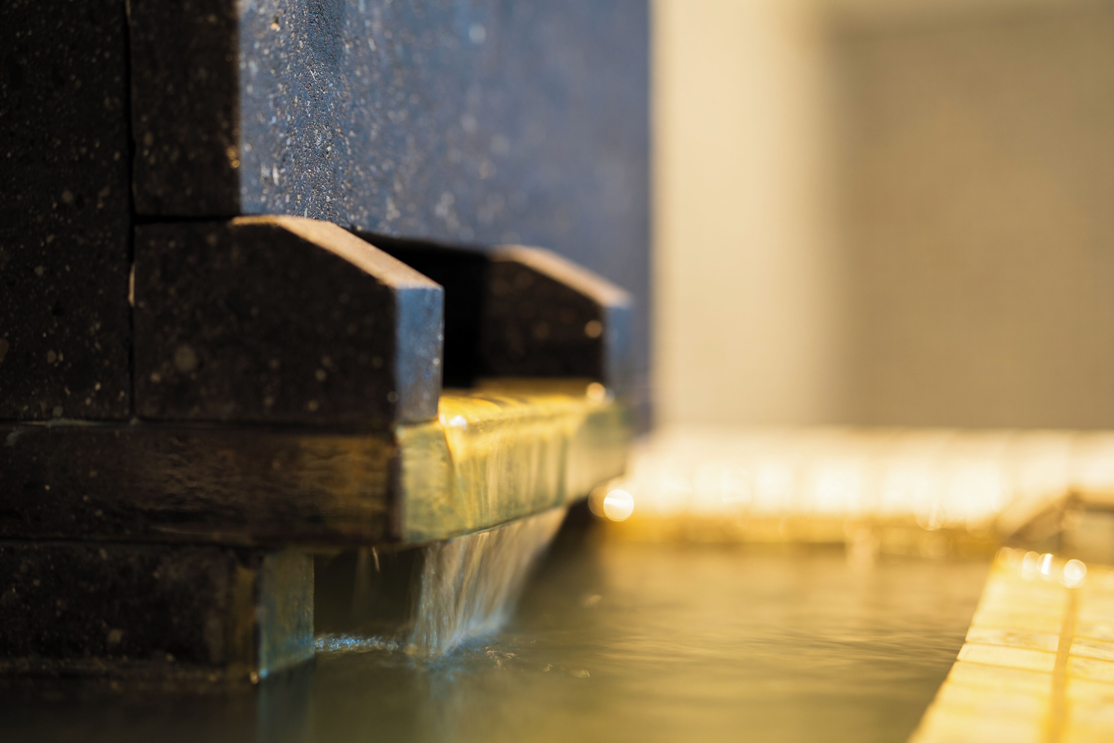 A close-up of a water feature with a stone structure and a reflective surface.