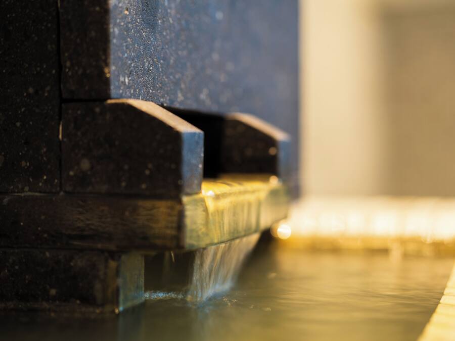 A close-up of a water feature with a stone structure and a reflective surface.