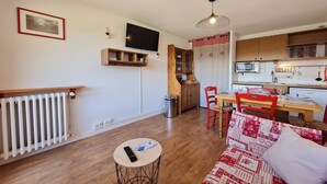 A compact living space with a kitchenette, a dining area, and a seating area with a sofa. - Ski-In Stay in Les Deux Alpes (Les Deux Alpes)