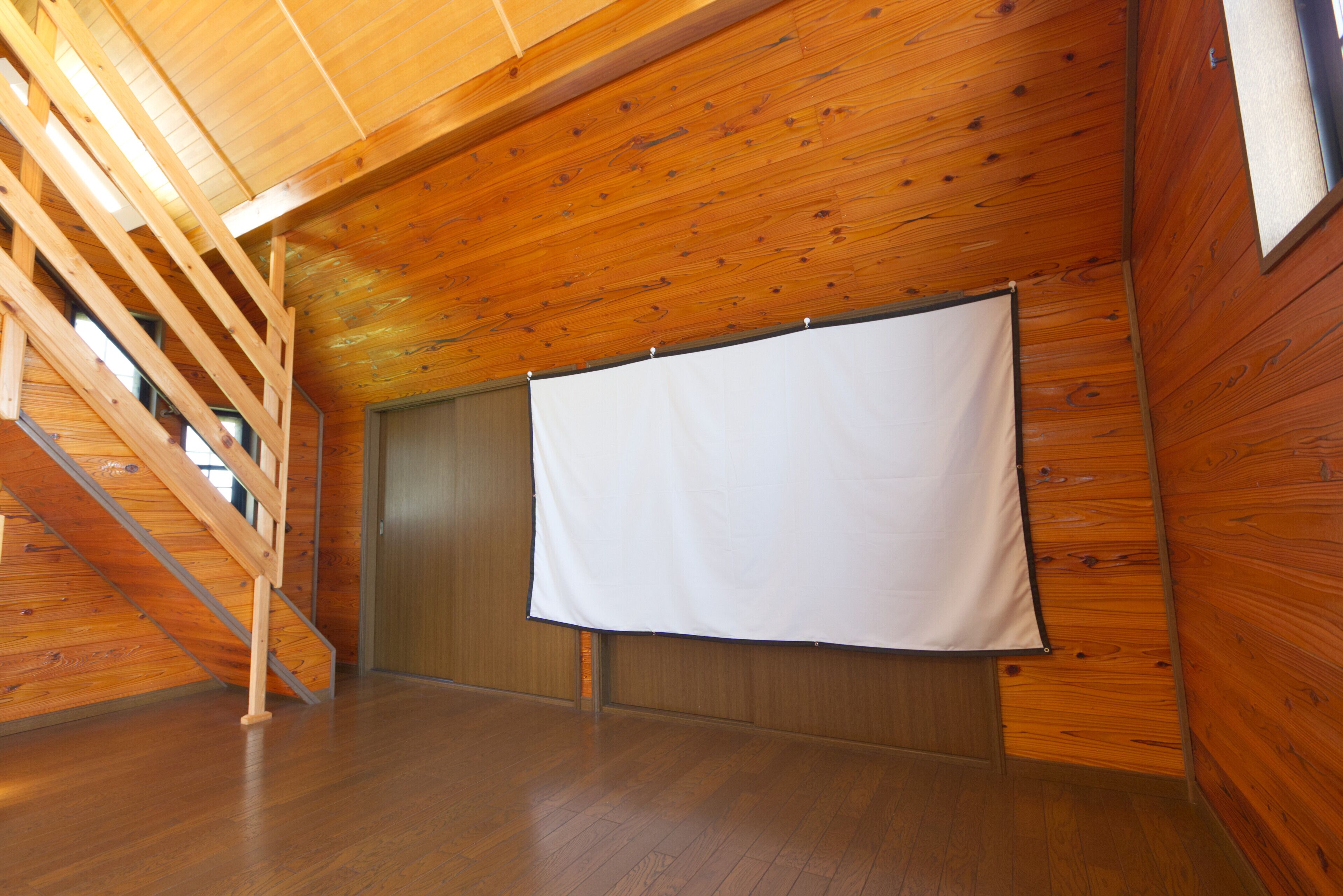 A room with wooden walls and a wooden staircase.