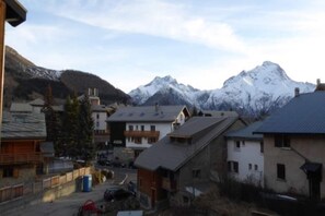 Un quartiere residenziale con case, una strada e montagne innevate sullo sfondo.