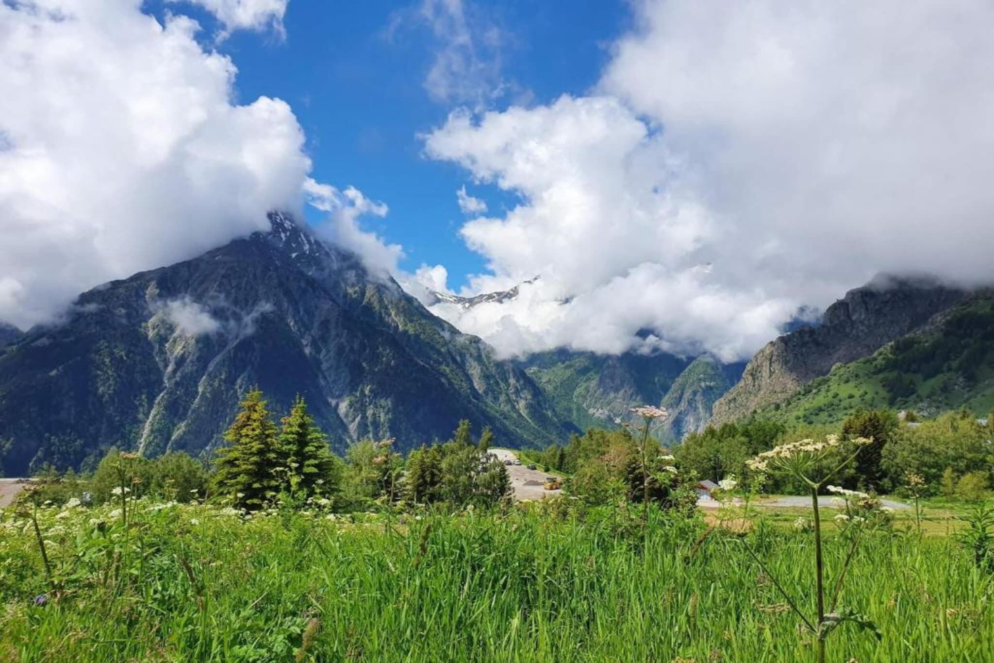 Un paysage montagneux, avec un ciel dégagé et des nuages.