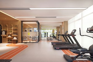 Un gimnasio con cintas de correr, pelotas de ejercicios y una pared con mensajes motivacionales.