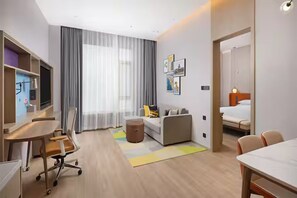 A modern hotel room with a desk, sofa, and bed. - Home2 Suites by Hilton Chaozhou (Chaozhou)