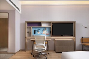 A hotel room with a desk, chair, TV, and a bed. - Home2 Suites by Hilton Chaozhou (Chaozhou)
