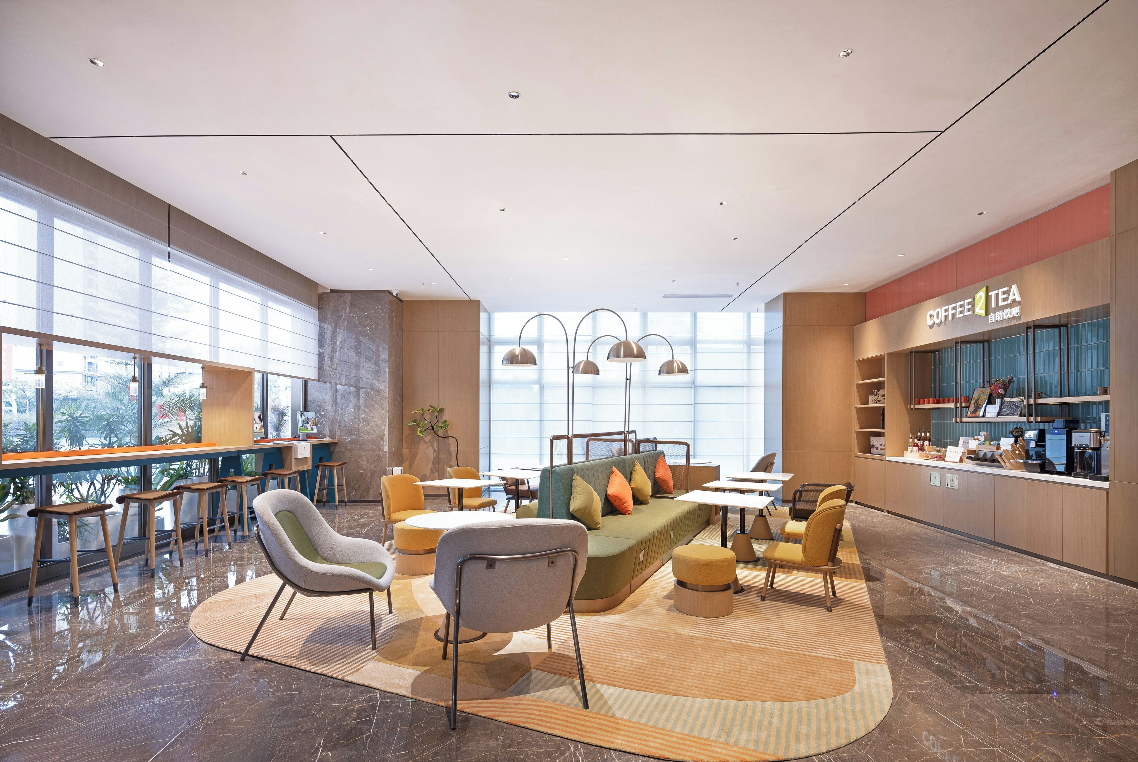 Un interior moderno con una zona de estar, bar y estación de café.