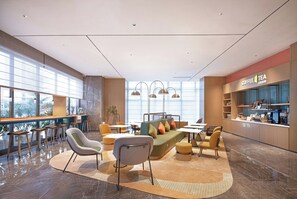 A modern interior with a seating area, a bar, and a coffee station.