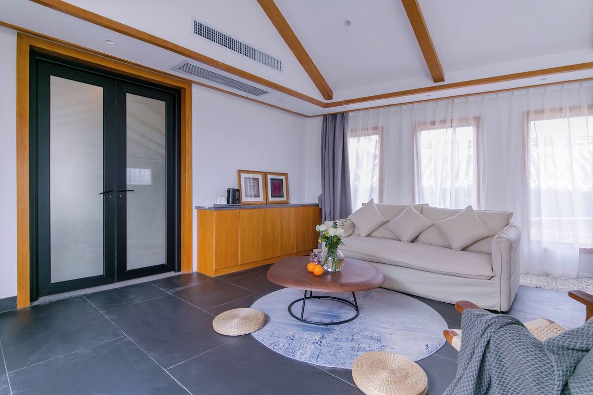 A modern living room with a sofa, coffee table, and a wooden cabinet.
