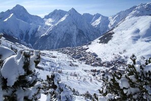 Paesaggio montano innevato con un paese situato nella valle.