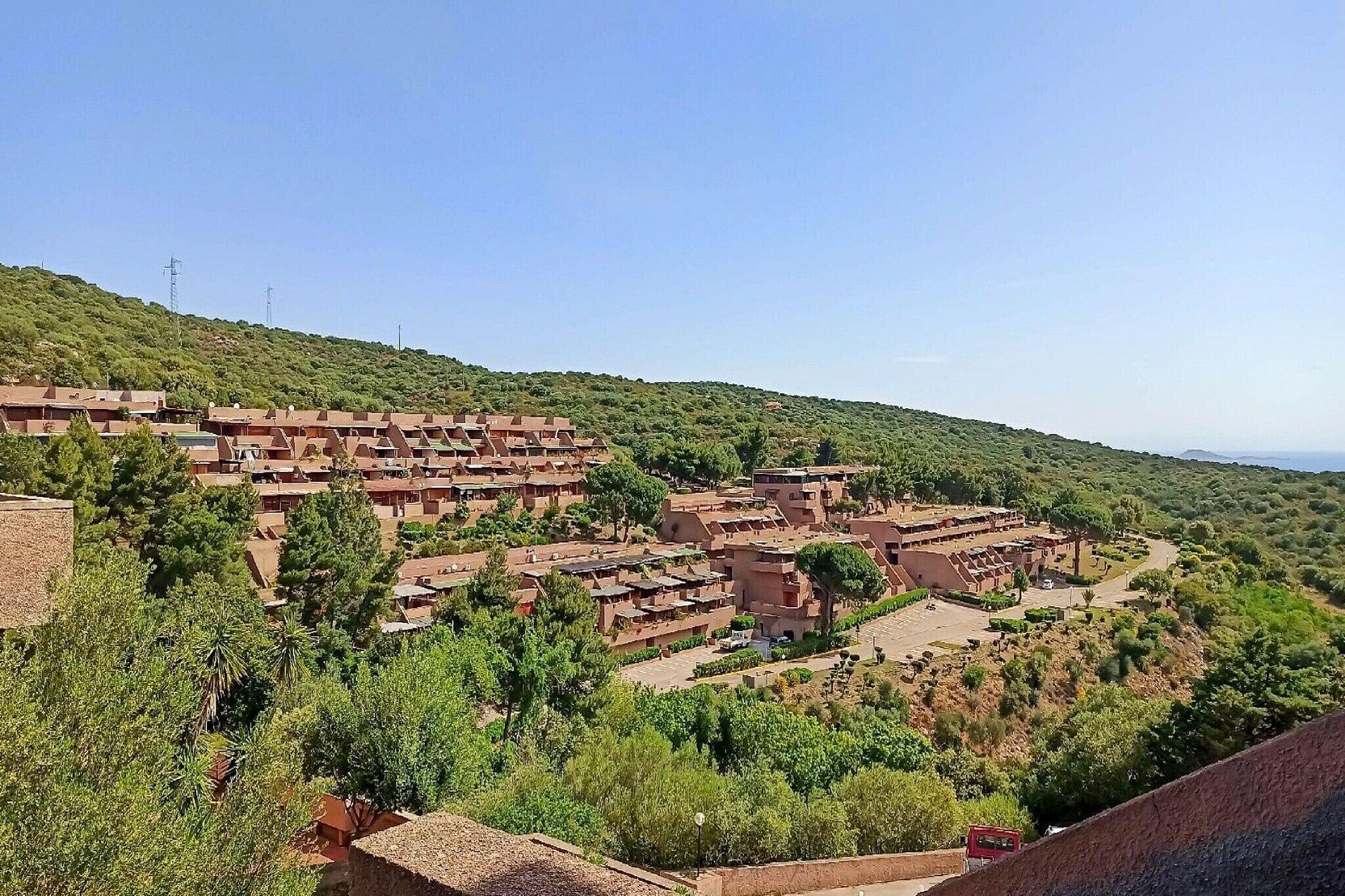 Ein Dorf an einem Hügel mit terrassenförmig angelegten Häusern und blauem Himmel.