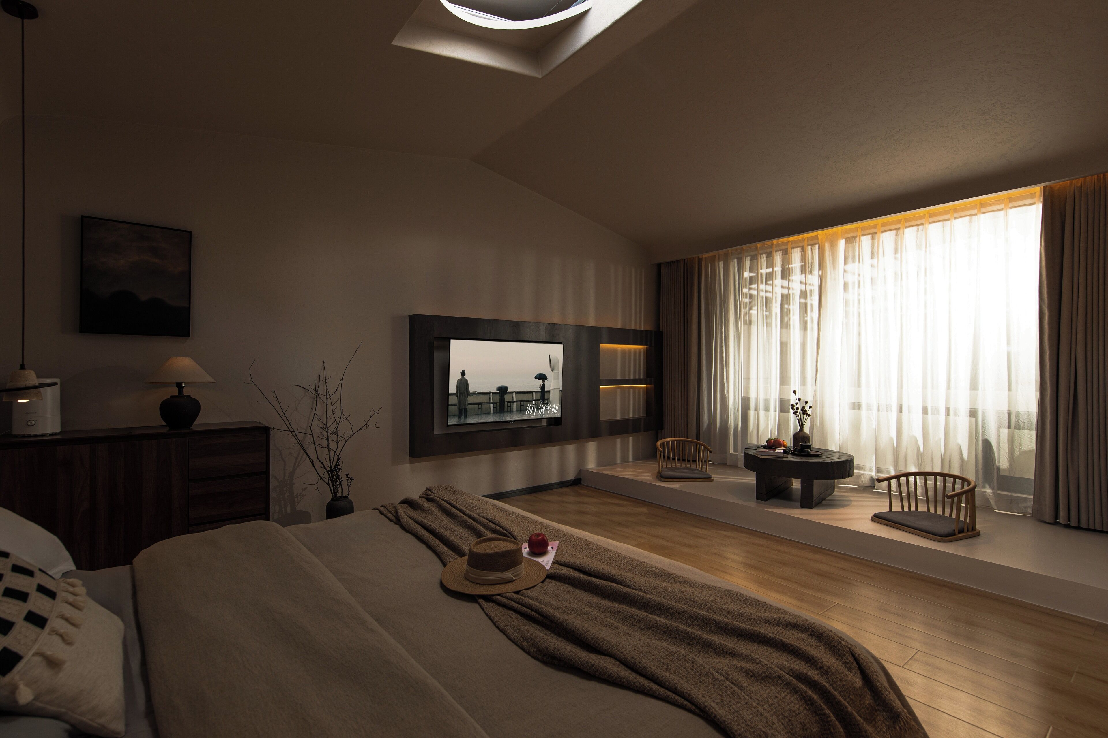 A modern bedroom with a large bed, a side table, a chair, and a window with curtains.