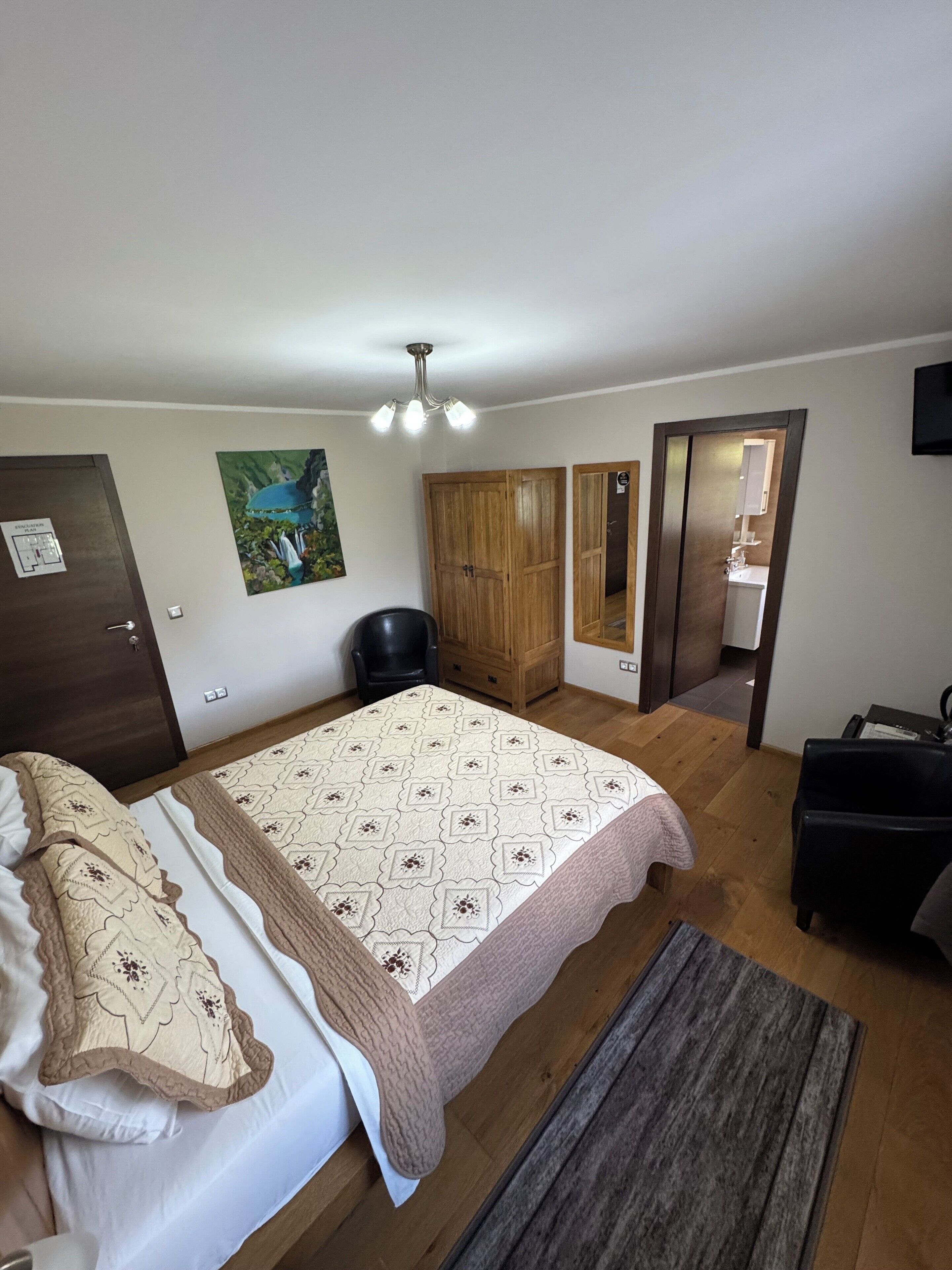 Un dormitorio con cama, un armario de madera, un escritorio y una silla.
