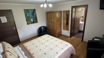 Un dormitorio con cama, un armario de madera, un escritorio y una silla.