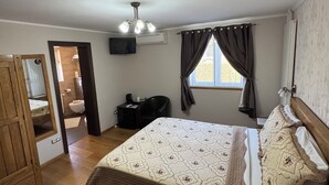 A bedroom with a bed, a desk, a chair, a window with curtains, a ceiling light, and a door leading to another room. - Millenium House (Plitvicka Jezera)