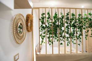 Un dormitorio con cama, cabecero de madera y planta en la pared.