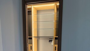 Un vestidor con estantes de madera, una percha y dos cajones.